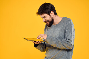 Man with a tablet in the hands of technology communication professional yellow background