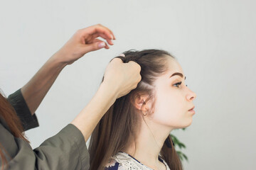 Fototapeta premium master makes a hairstyle for a girl, beautiful curls