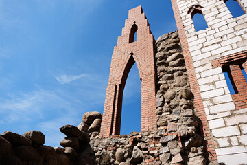 The ruins of an ancient brick castle against the blue sky