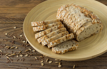 Gluten-free vegan bread with no animal products. Vegetarian bread with oatmeal, banana flavor on a plate on a wooden rustic table, sliced and ready to serve.
