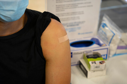 Latino Male With Band Aid On Shoulder After Getting Vaccinated