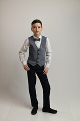 Photo of a teenager boy in full growth in a suit on a white background in different poses