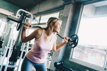 Fototapeta na wymiar Sport women lift up barbell in fitness gym