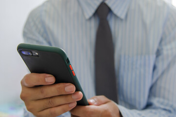 Close up hand holding businessman using mobile smart phone communicate online browse internet.