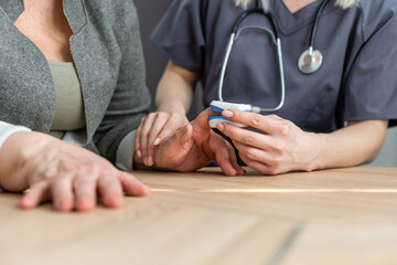 Doctor measuring patients hemoglobin level. Showing usage of finger pulse oximeter