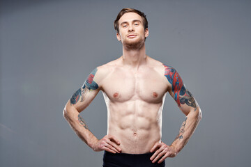 athletic man with pumped up abs tattoos on his arms