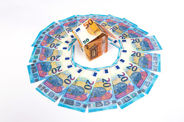 abstract house of 50 euro banknotes in the middle of the circle of 20 euro money, isolated on white