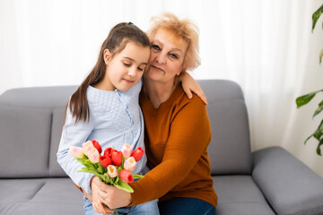 Fototapeta na wymiar Little girl visiting her ill grandmother giving flowers