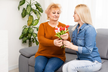 Fototapeta na wymiar child daughter congratulates mother and gives a bouquet of flowers tulips
