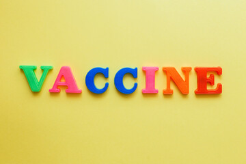 the word vaccine on a yellow background