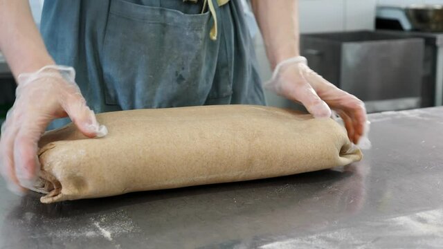 The pastry chef prepares the dough for rolling. The process of making puff pastry.