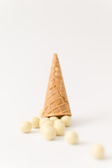 Cornet and chocolate balls on a light and white background.