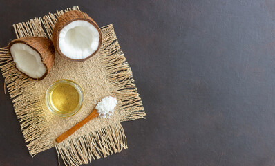 Fototapeta na wymiar Coconut oil in a jar and fresh coconuts on a beige background. Natural cosmetics.