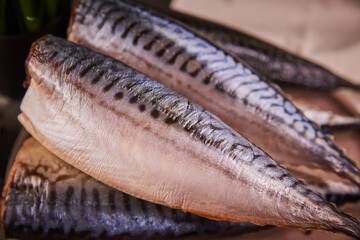Fresh raw fish Mackerel mackerel on a round plate on the gray kitchen table. the concept of cooking fresh fish with salt and vegetables