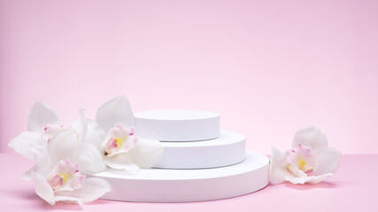 White geometric shapes podium for product display on pink background with orchid flowers and palm leaves. Monochrome stage, stand for product promotion in minimal style. Copy space for your design