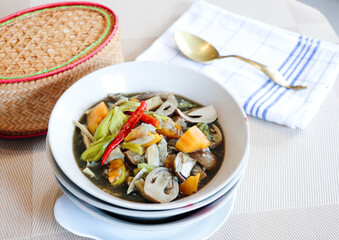 image of local Thai food from north eastern called Keang nor mai served with sticky rice in bammboo container.