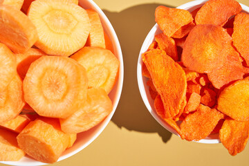 Fototapeta na wymiar Crispy dried food. Organic tasty chips. Homemade snacks. Sliced carrot. Healthy vegetables. Orange pile
