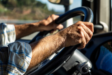 Manos de un conductor profesional en el volante de un vehículo mientras circula por la carretera.
