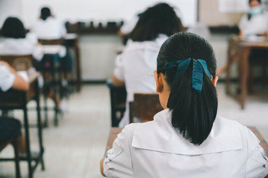 Students doing exam in classroom with stress