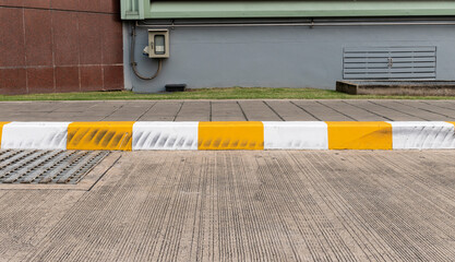 Yellow and white color curb stained with tires.