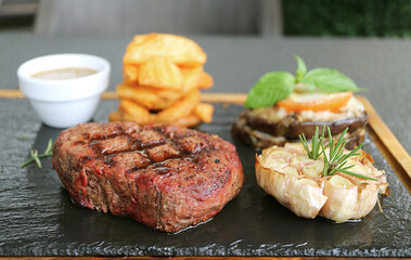 Delectable Medium Well Grilled Filet Mignon Steak with Grilled Vegetables on Hot Stone Plate
