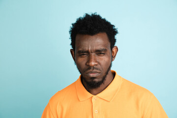 Obraz premium African man's portrait isolated over blue studio background with copyspace