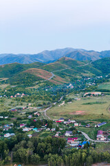 Big mountains ladscape. Mountain river top view. Scenery with little houses at the foot of the mountain and river.