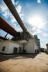 Standard Cement plant. Rotary clinker kiln, industrial building and tubes. Blue sky background
