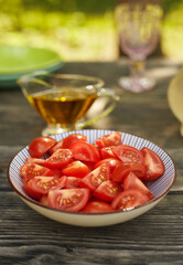 Sliced tomatoes in a bowl are ready to eat. Composition in a fresh authentic atmosphere