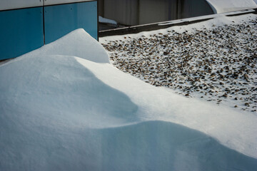 Snow dunes on the roof of a building