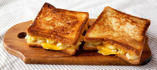 Homemade Grilled Macaroni and Cheese Sandwich on a rustic wooden board, side view.