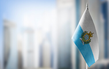 A small flag of San Marino on the background of a blurred background