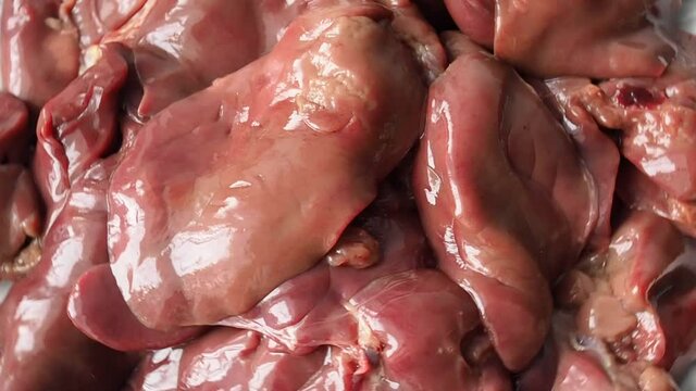 Raw chicken liver rotates, close-up, selective focus. Background of poultry liver, meat food
