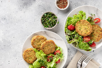 Green broccoli and quinoa burgers in plates with salad. Plant based diet concept. flat lay. copy space