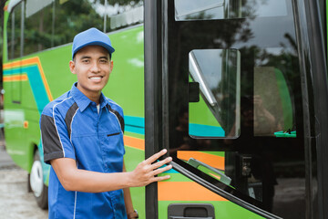 a bus driver in a uniform and a hat opened the bus door when he was about to get on the bus