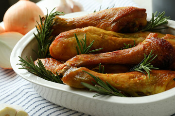 Concept of delicious eating with baking tray with roast chicken drumsticks
