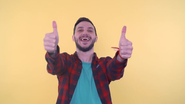 Excited bearded man looking at camera smiling, yelling YES and giving thumbs up