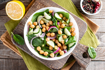 Spinach, cucumber, chickpeas, onions and lemon salad on a table. Top view