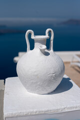 Naklejka na ściany i meble White greek amphora outdoors decoration. Sea in the background