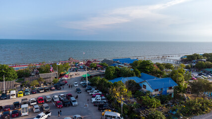 Fototapeta na wymiar Photo from drone on car park of wooden red long bridge at seaside of samut sakhon province,Thailand.