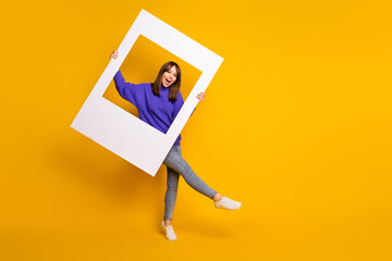 Photo of adorable charming young woman wear purple sweater dancing holding white photo frame...