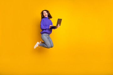 Fototapeta na wymiar Full size profile side photo of young happy cheerful excited girl jumping with laptop in hands isolated on yellow color background