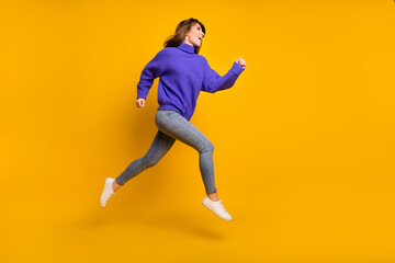 Fototapeta na wymiar Photo of funky adorable young lady dressed violet sweater jumping running fast isolated yellow color background