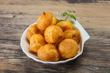 Sweet tasty profiteroles heap in the bowl