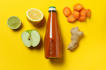 Bottle of juice and ingredients on yellow background