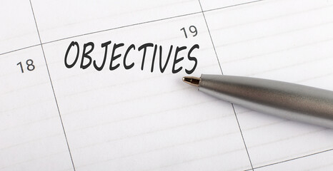 Text Objectives written on a calendar planner to remind you an important appointment with a pen on isolated white background.