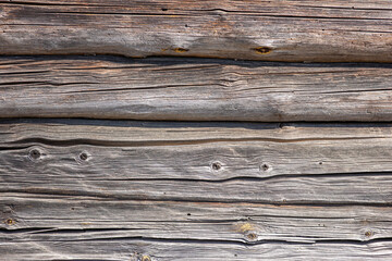 Fototapeta premium Wall of an old wooden house built from hand-hewn pine logs. Colorful textured old wood background