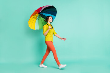 Full length body size view of attractive cheerful girl holding parasol going isolated on bright...