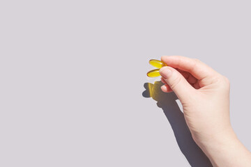 Omega3 gel capsule. Sun shadow. Yellow vitamin. Health eating. Dietology drug. Fish oil supplement. Nutritional concept. Golden softgel collagen. Medicine immunity cosmetics