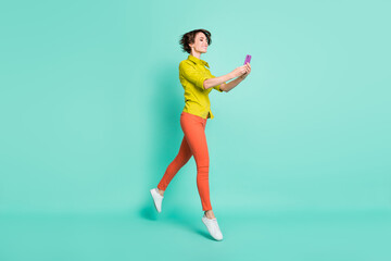 Fototapeta na wymiar Full length body size photo of female blogger taking selfie usinf smartphone isolated vivid turquoise color background